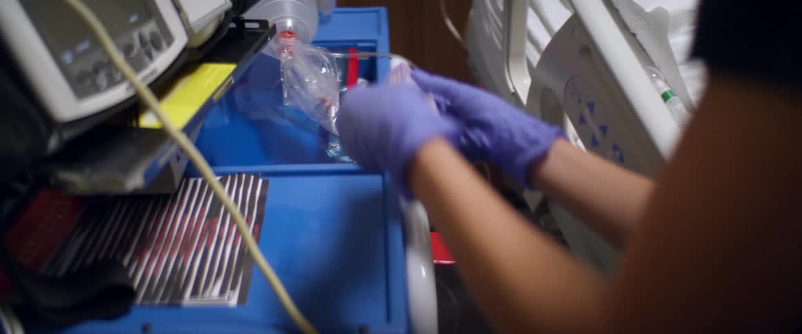 A nurse opens a box and removes a syringe