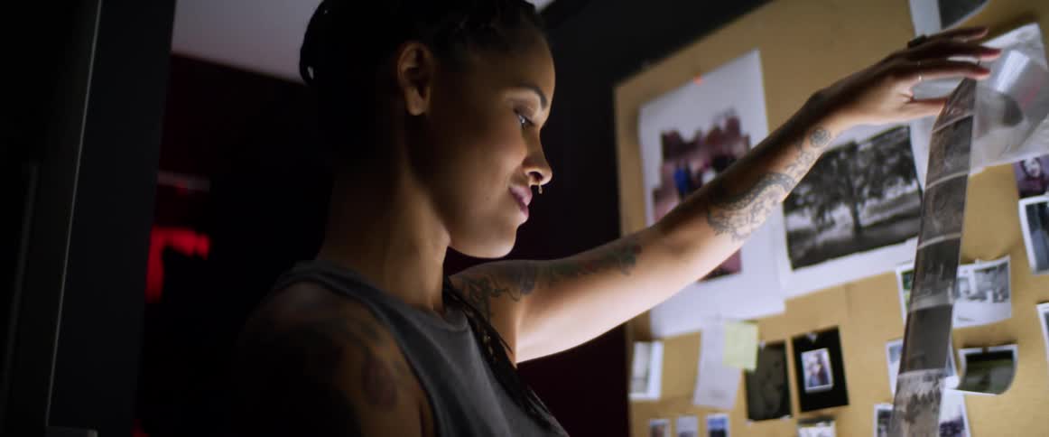 Tattooed woman checks film roll in studio