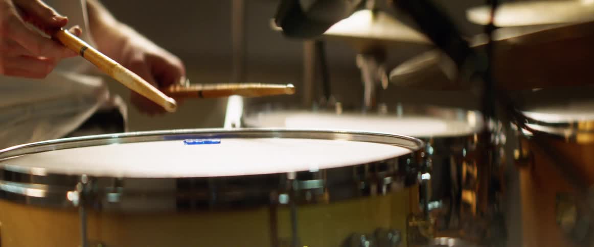 A musician sits at the drums