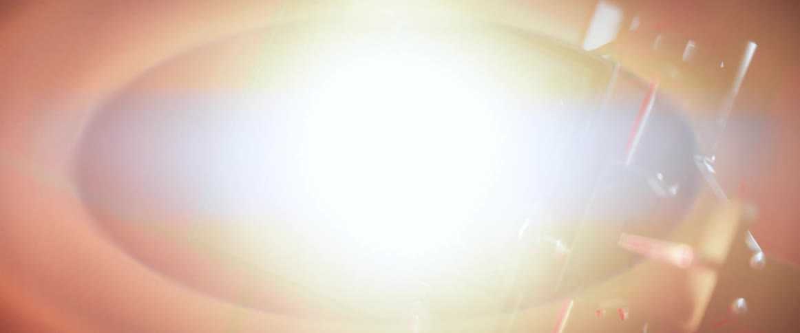 A person takes a lens off a camera to reveal a bright light