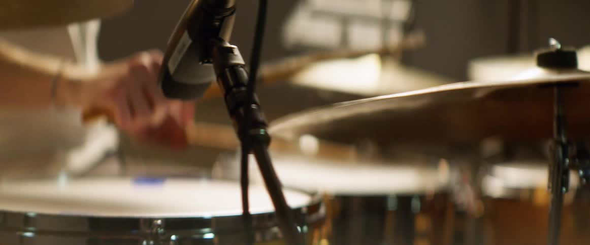 A man is playing the drums indoors
