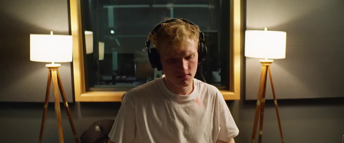 A man with headphones sitting and playing the drums