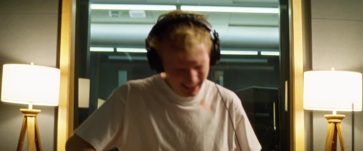 A man is playing drums indoors