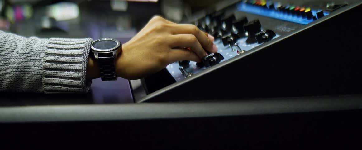 A person turns a dial on a communications machine