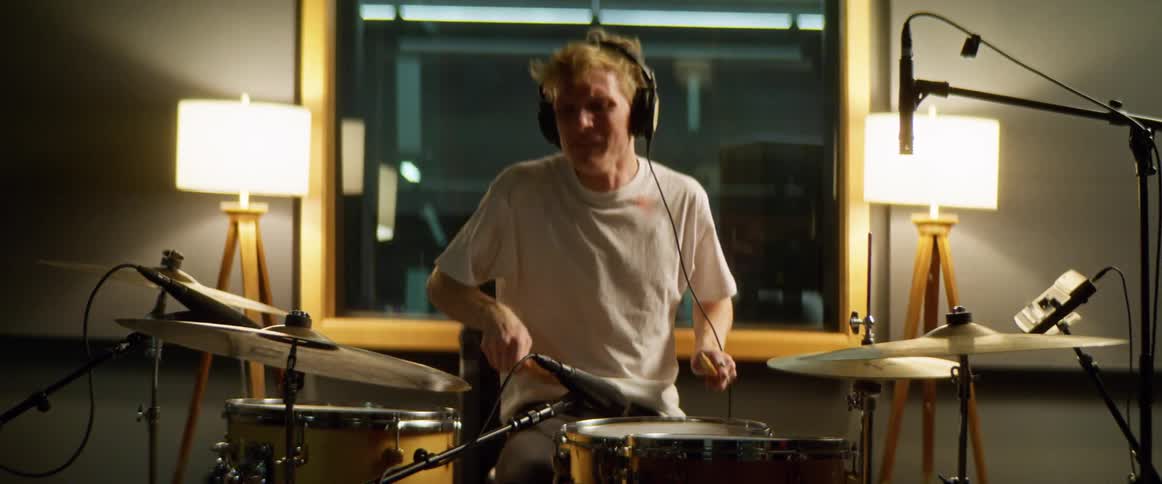 A teenage boy plays the drums