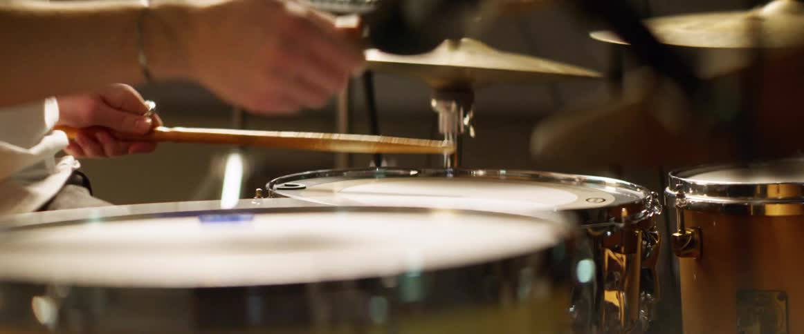 A white male plays a drum kit