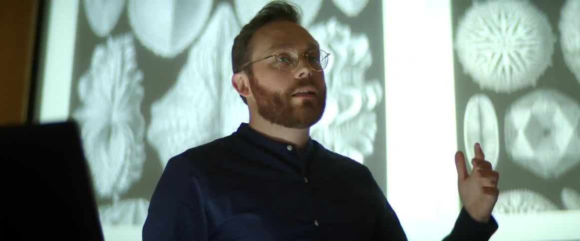 A professor presents slides and delivers a lecture in class