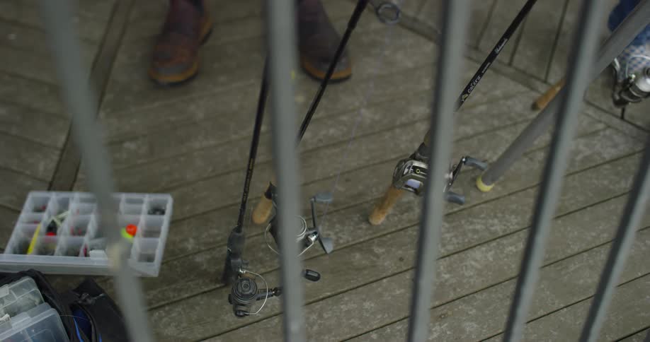 A person is setting up all their fishing rods by the gate
