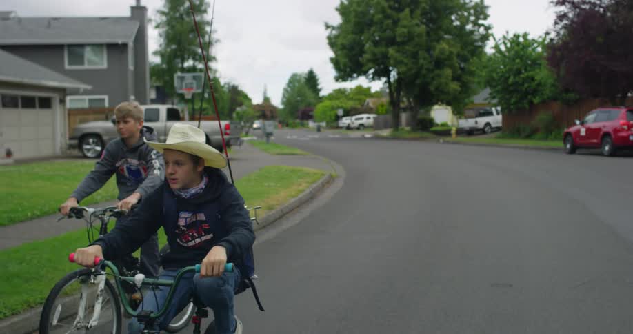 Two boys cycle along the road in the neighborhood