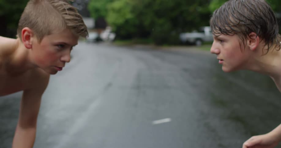 Shirtless teenagers play basketball on the streets of the neighborhood