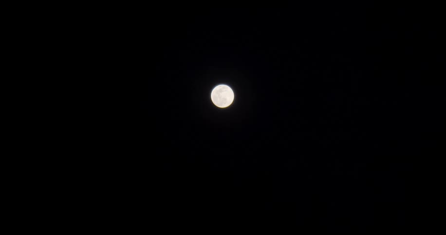 The moon shines brightly in the night sky