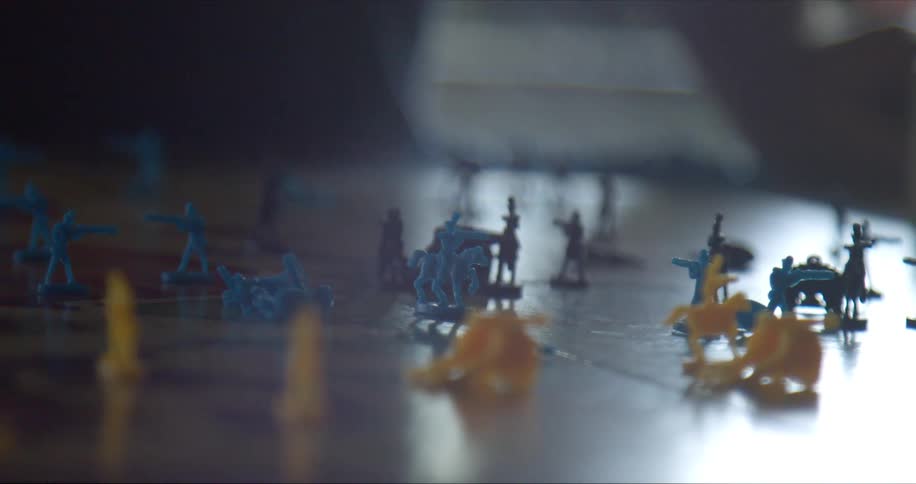 Small plastic yellow and blue toy army men on table top