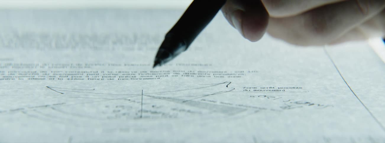 Designer holds a pen while reviewing a diagram on a back light surface