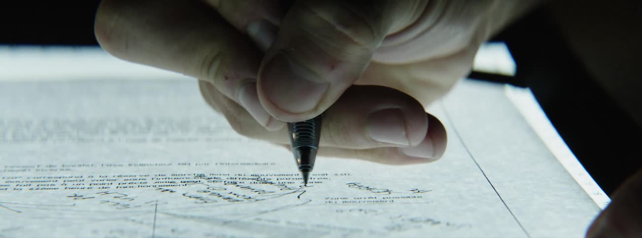 A man is writing on a piece of paper