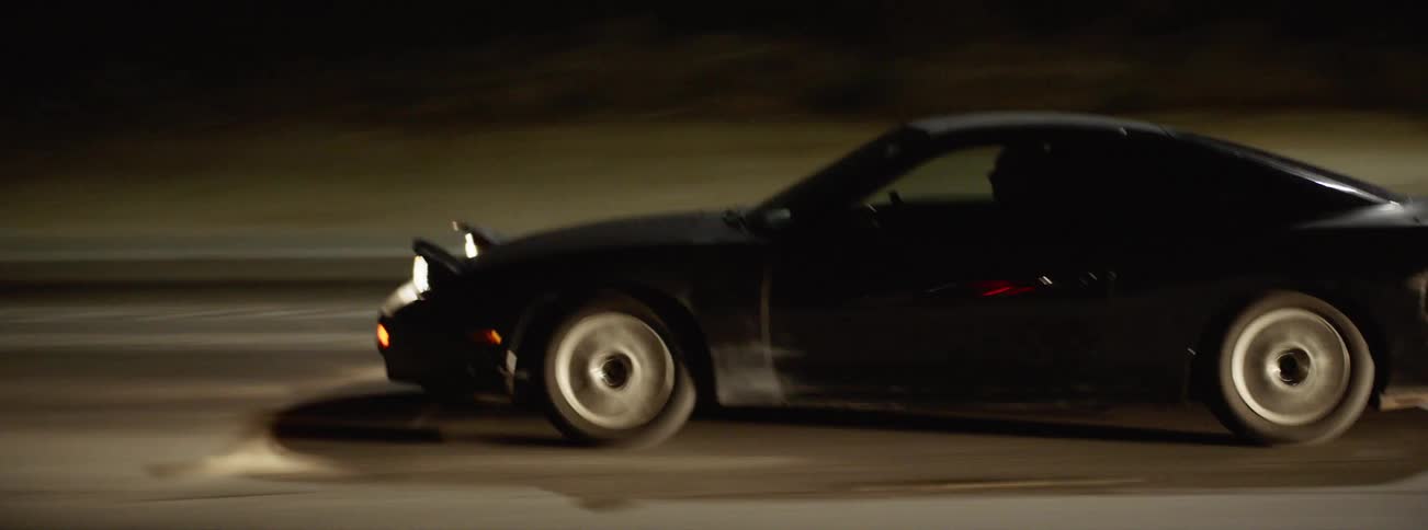 Car speeding down freeway at night from window of moving vehicle