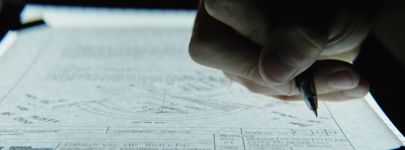 Hand making diagram and notes on drafting paper