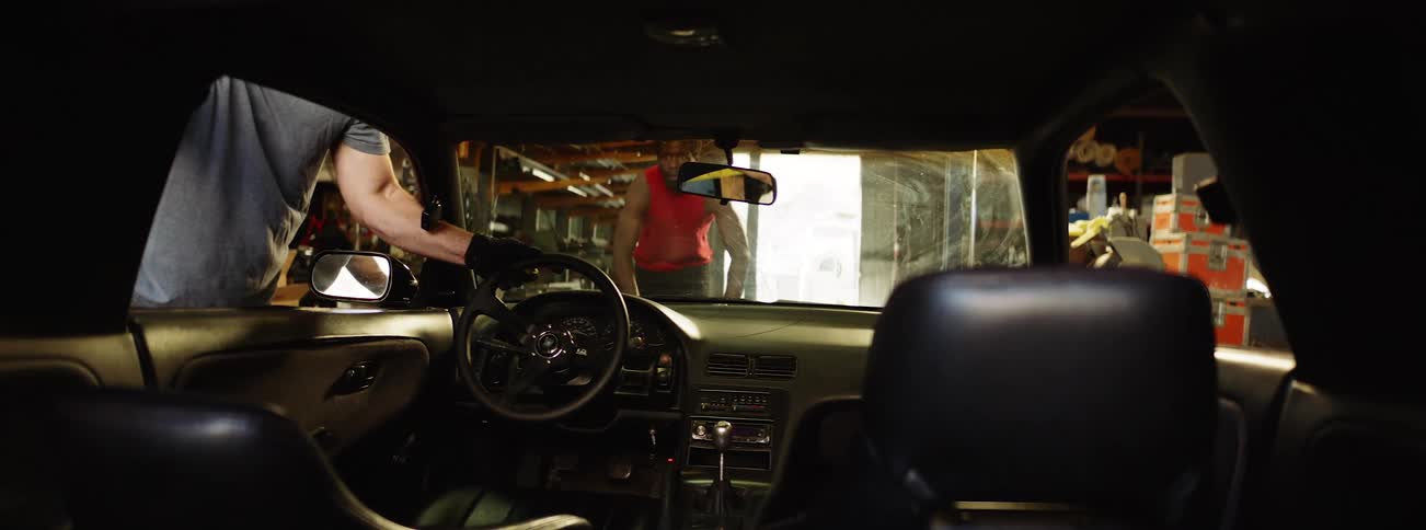 A man pushes a car into the garage