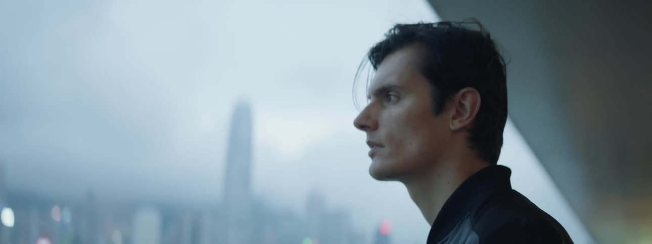 A man looks out over the fog covered city