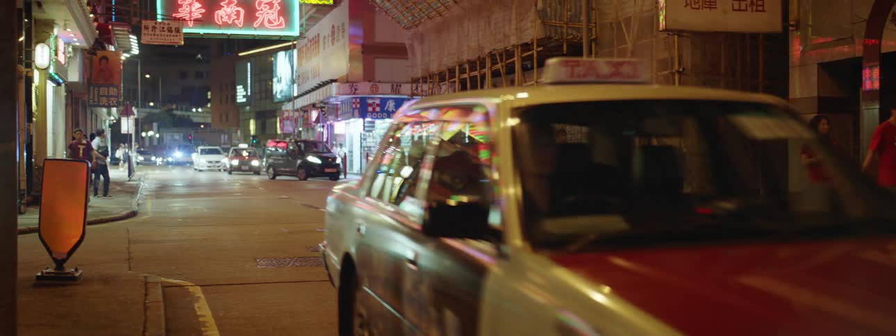 Cars are driving through a city at night
