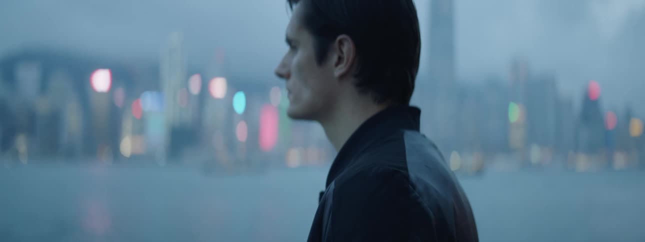 A man stares across the ocean to view the downtown skyline on the other side of the water