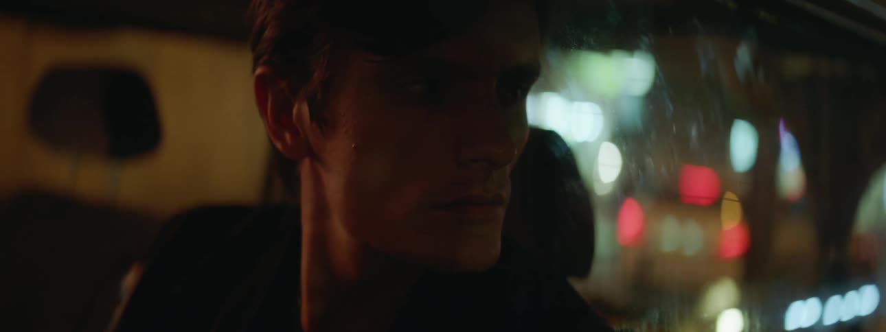 A white man sits in a car and looks out the window