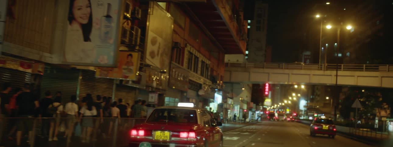 Car driving on the street through city downtown at night