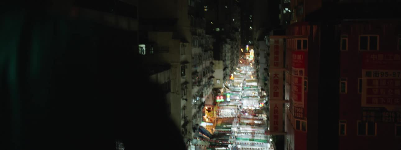 Young man wearing leather jacket looks at city streets at night