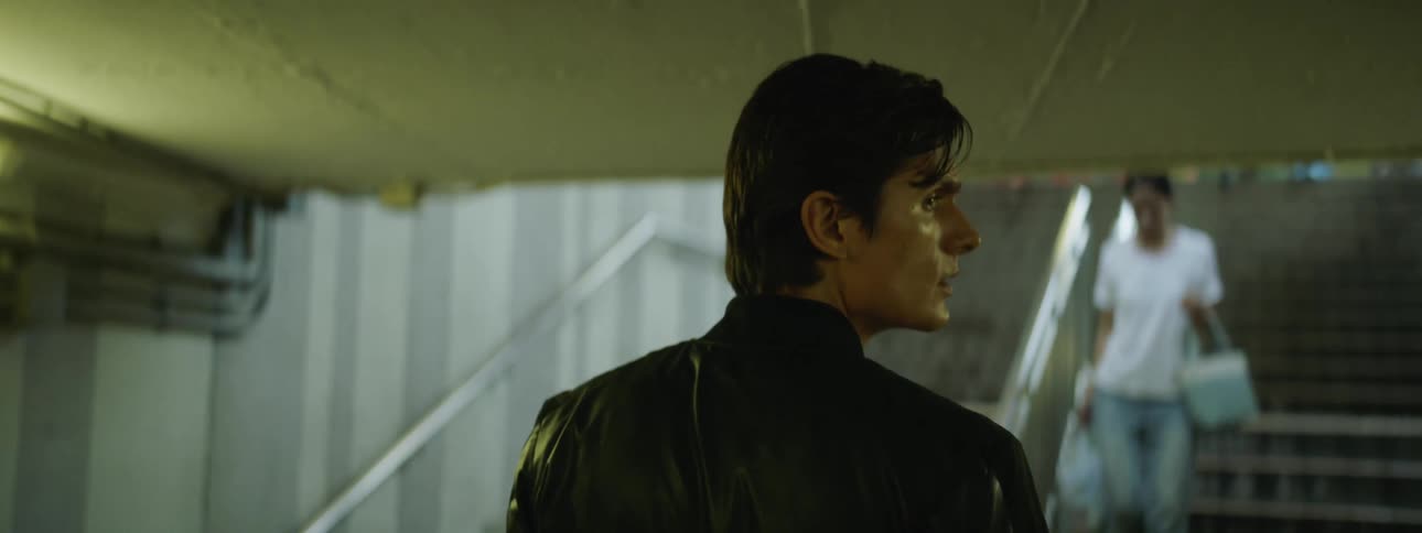 A man is walking out of the subway towards the stairs