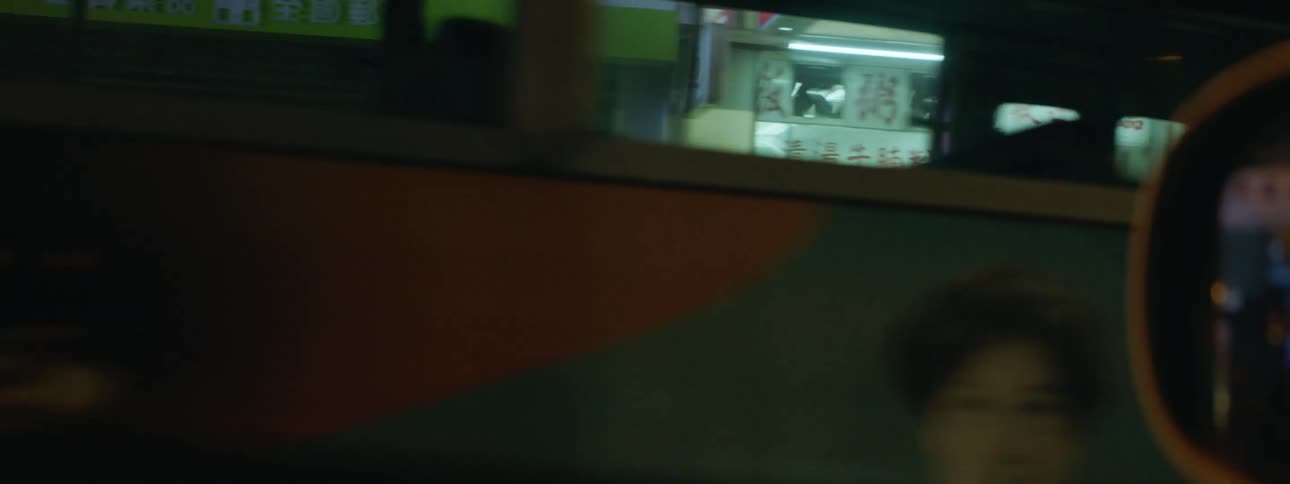 A car drives past the busy city at night
