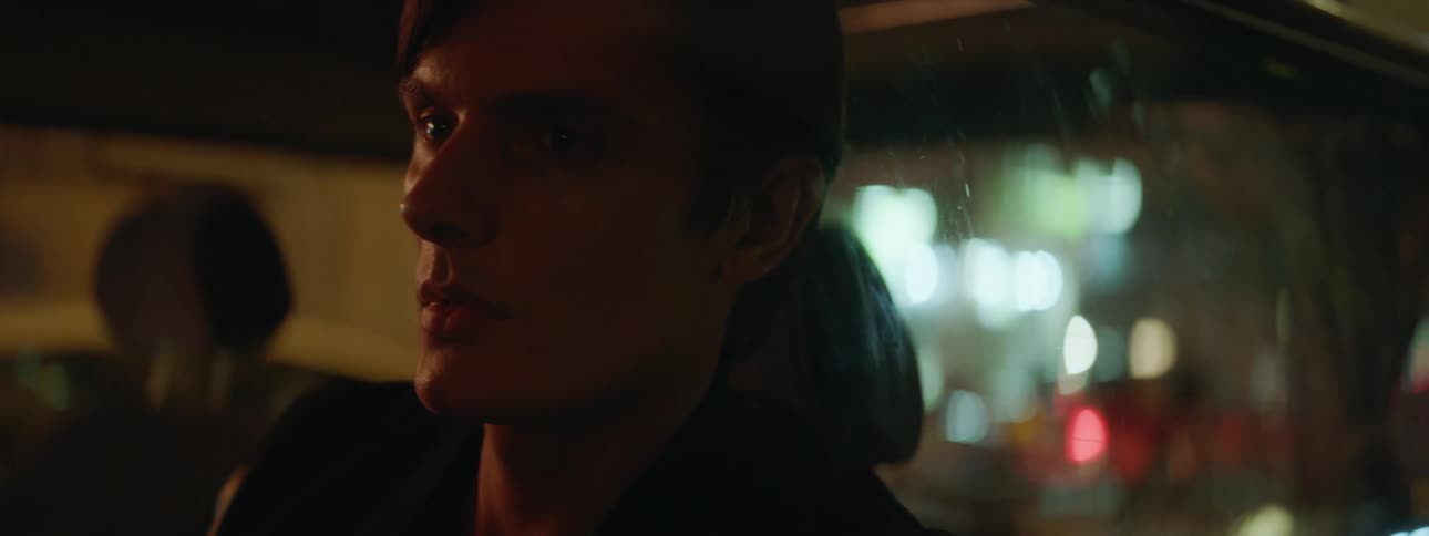 Man looks out window of taxi at night