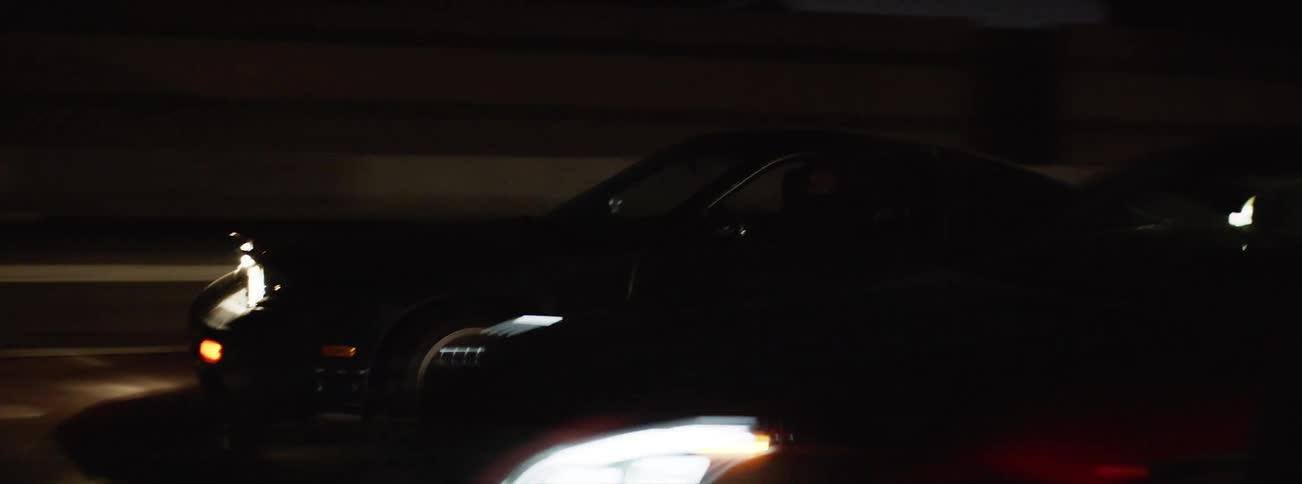 A dirty car drives on a busy highway
