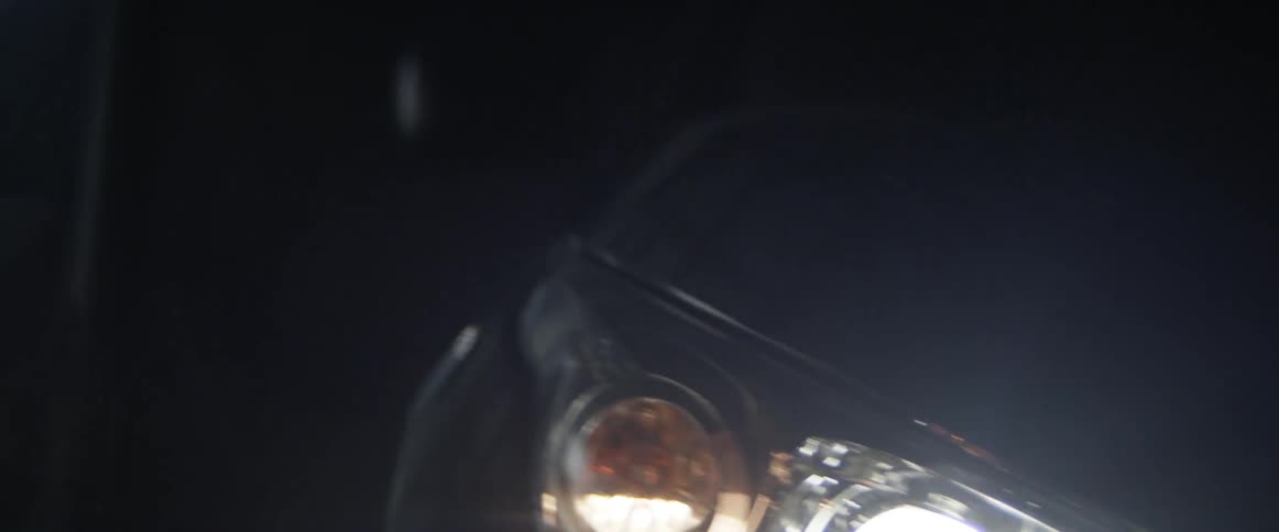 Close up of a car headlights on a dark room