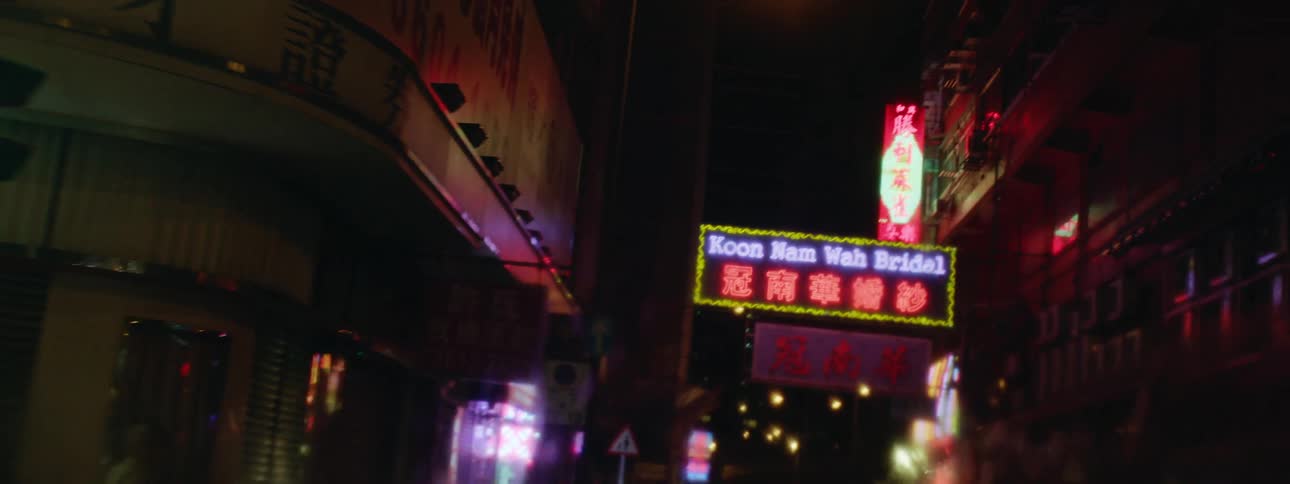 A car drives down the city street at night
