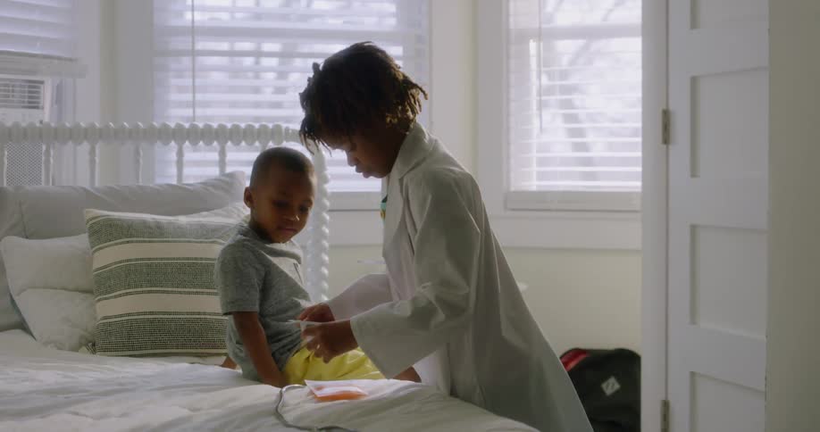 Young girl pretends to be a doctor and treats a male pretend patient
