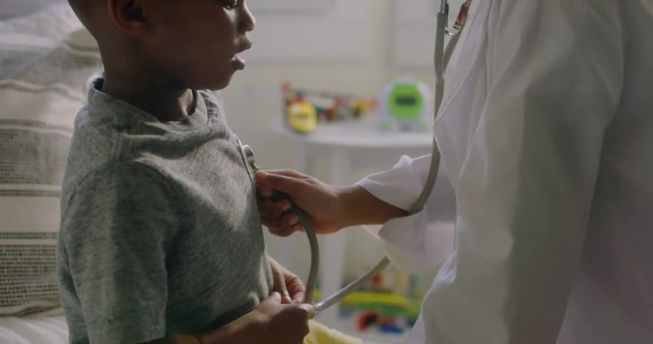 A girl with a stethoscope playing and listening to a boys heart