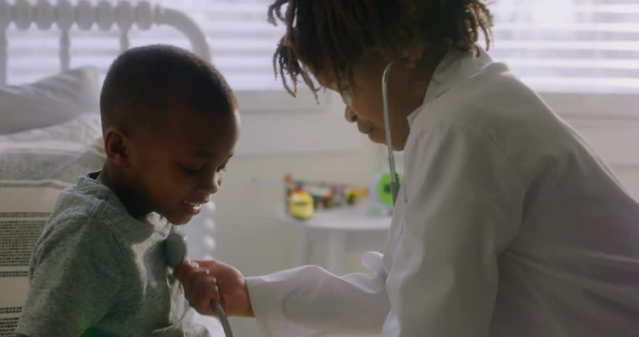 A doctor listens to a young boys chest with a stethoscope