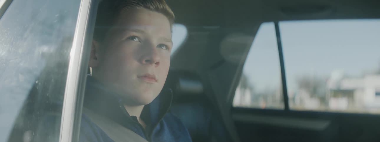Boy looks out the side window of a car