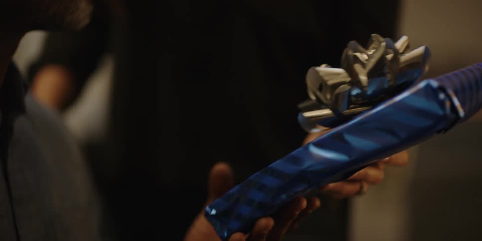 Woman hands man a gift wrapped present