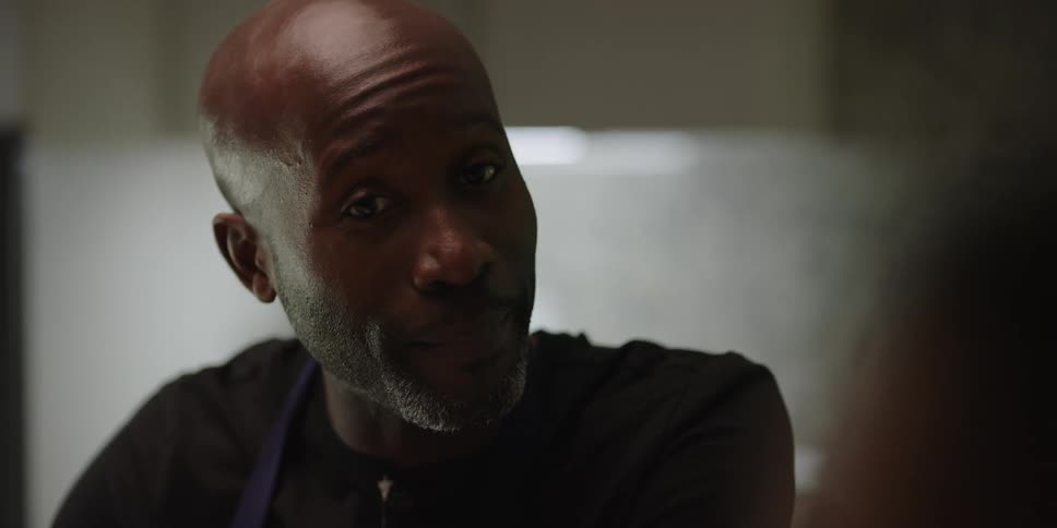 A man is talking with others in the kitchen