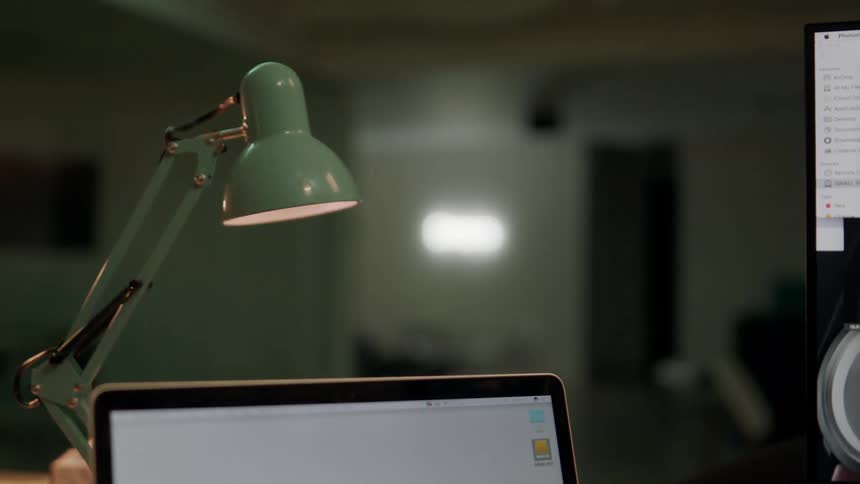 Overhead desk lamp flickering above laptop