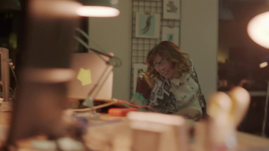 A woman in an office touching a laptop during an earthquake