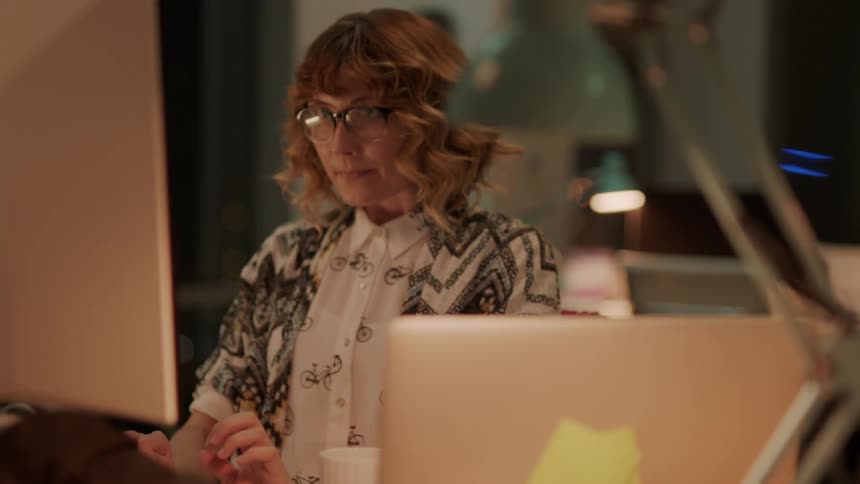A woman sitting in front of a computer typing