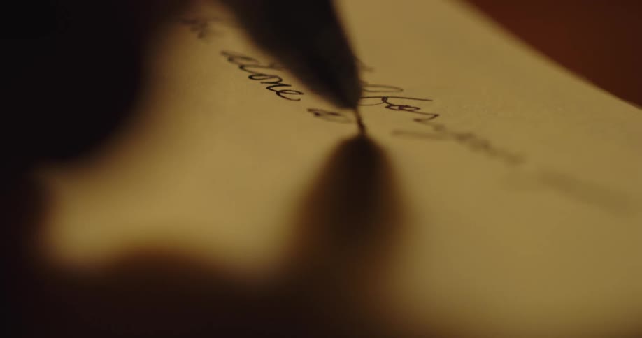 Pen handwriting on paper in a dimly lit room