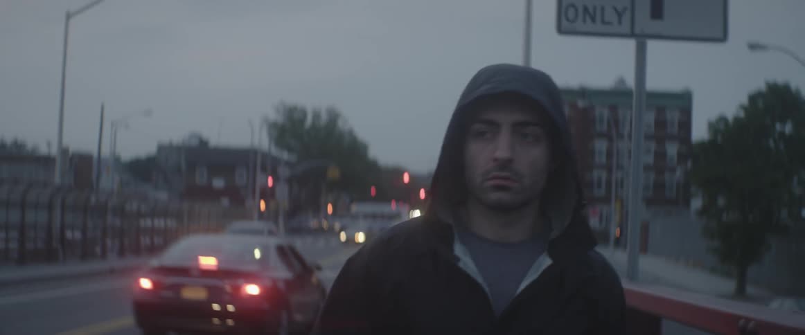 A man walks down a city street at night
