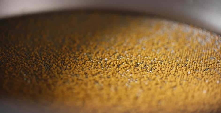 Orange granules bounce inside a machine
