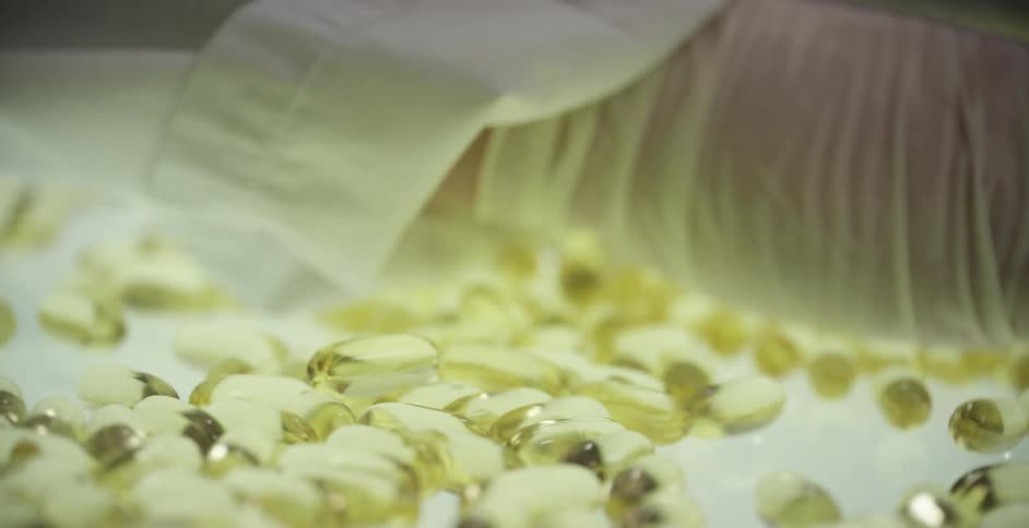 A woman spreads capsules out