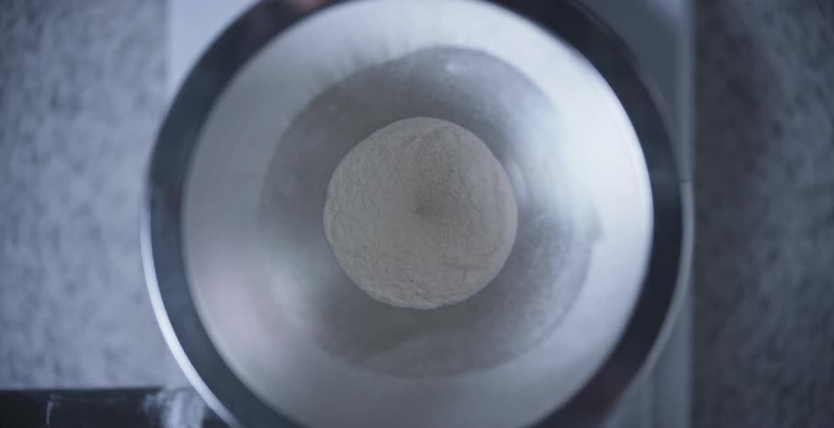 Birds eye view of flour sifting through a funnel in a factory