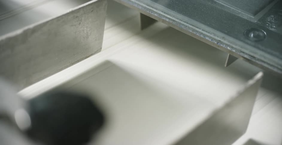 Two pieces of metal slide through a machine