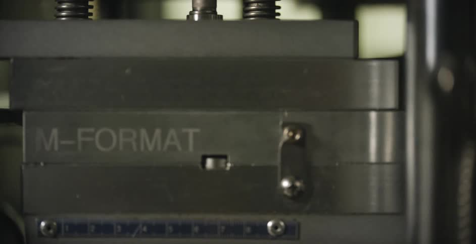 A machine rises to seal pill packs moving by
