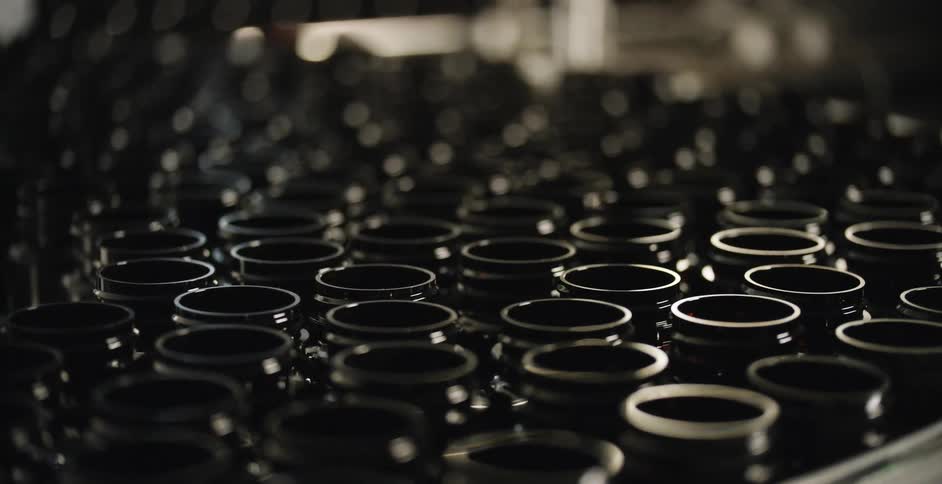 Empty glass bottles on conveyor belt with blurred background